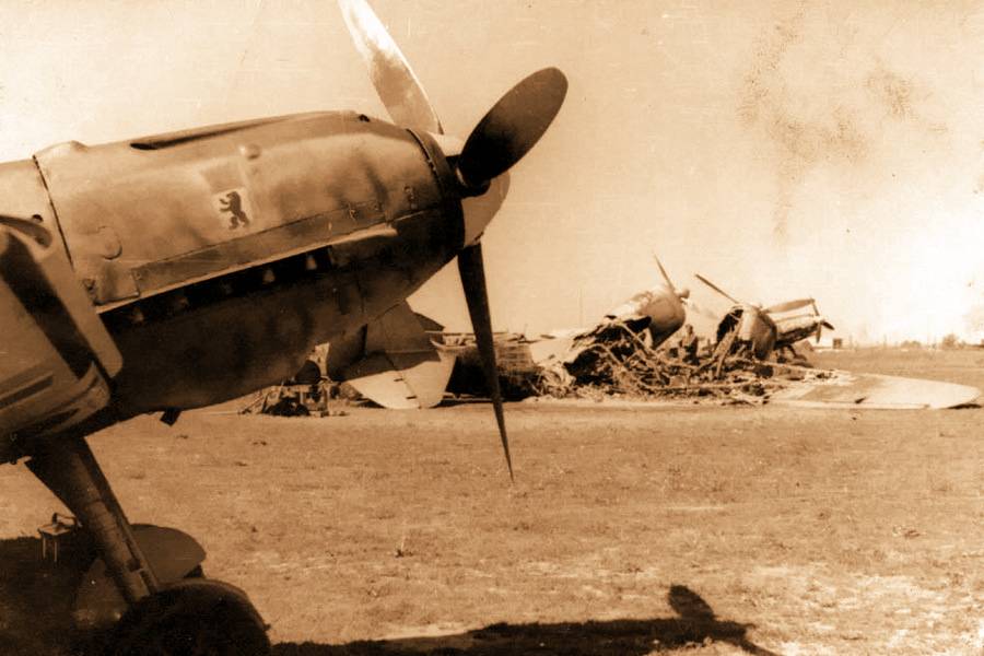 Bf 109E из состава II./JG 27, аэродром Парубанек (Вильнюс), июнь 1941 года. На заднем плане уничтоженный в ходе предыдущих налётов СБ из состава 54-го СБАП (коллекция автора)